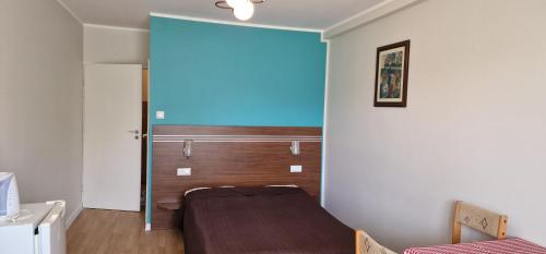 a bedroom with a bed and a blue wall at Róża Wiatrów 2 Władysławowo in Władysławowo