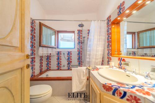 a bathroom with a sink and a toilet and a tub at Villa Romazzino con vista mare in Abbiadori