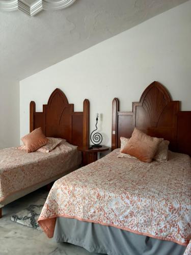two beds sitting next to each other in a bedroom at Domus Áurea in Mazatlán