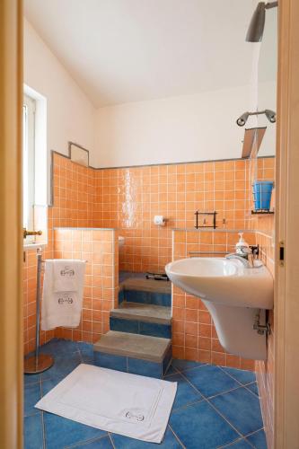 a bathroom with a sink and orange tiles at A Casa da Carol in Montecorice