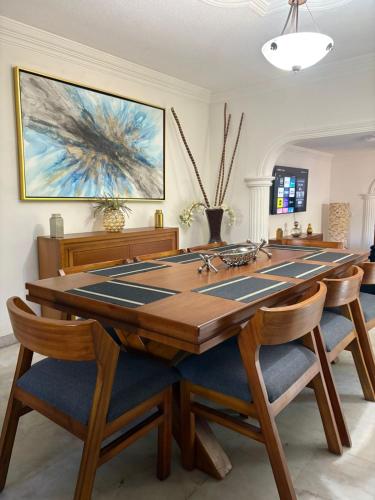 a dining room with a large wooden table and chairs at Domus Áurea in Mazatlán