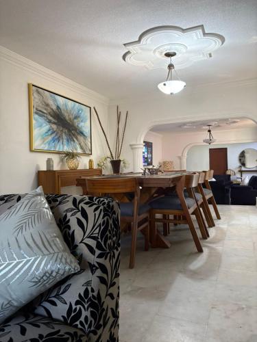 a living room with a couch and a dining room table at Domus Áurea in Mazatlán