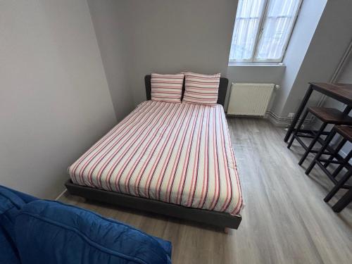 une chambre avec un lit avec deux oreillers dessus dans l'établissement Studio rénové - Centre Ville de semur, à Semur-en-Auxois