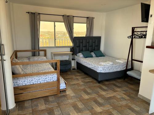 a bedroom with two beds and a window at Casa Bita Morales CASA 201 in Cartagena de Indias