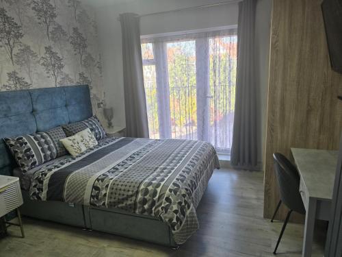 a bedroom with a bed and a large window at Martello Bay Hotel in Clacton-on-Sea