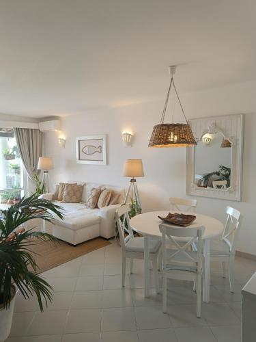 a living room with a white couch and a table at Ocean Terraces Vila Gaivota I in Ferragudo