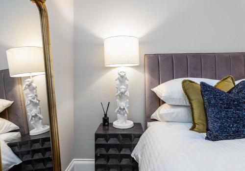 ein Schlafzimmer mit einem Bett mit einem großen Spiegel in der Unterkunft Arlington Apartments - City Centre Luxury Apartments in Glasgow