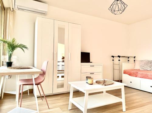 - une chambre blanche avec un lit, une table et un bureau dans l'établissement Studio cosy a juan les pins, à Antibes