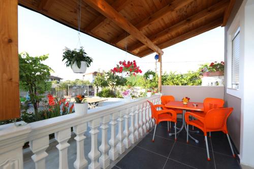 a balcony with orange chairs and a table at Guest House Narta in Vlorë