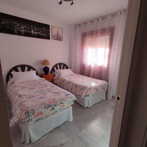 a bedroom with two beds and a window at Hidalgos SolyGolf in Manilva