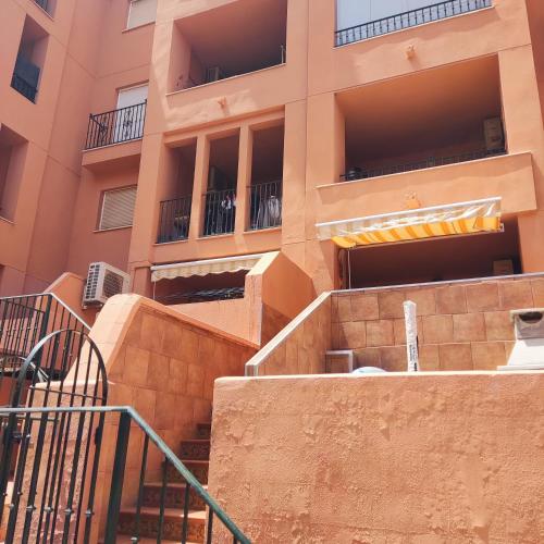 an apartment building with stairs in front of it at Hidalgos SolyGolf in Manilva