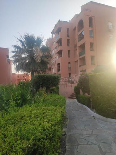 a walkway in front of a building with a palm tree at Hidalgos SolyGolf in Manilva