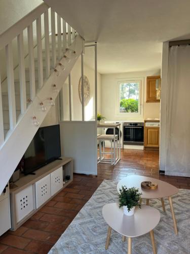 un salon avec un escalier et une table dans l'établissement Maison zen Lacanau Océan 3 personnes, à Lacanau