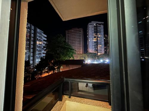 a view of a city at night from a window at Flat Sun Square in Goiânia