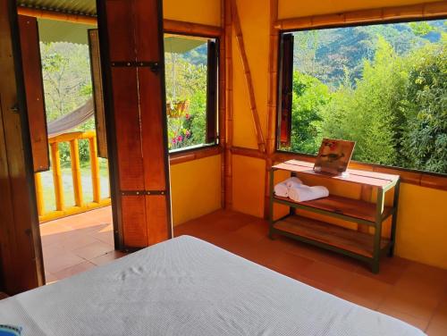 a bedroom with a bed and a desk and windows at Soñarte Vital in Córdoba
