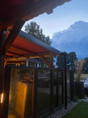 a glass extension to a house with mountains in the background at Der Tanzhase in Hasenmoor
