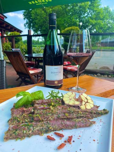 a plate of food with a bottle of wine and a glass at Der Tanzhase in Hasenmoor