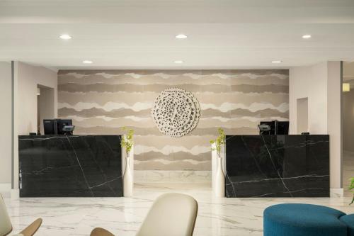 a lobby with two black screens and a wall with camouflage at Fairfield Inn & Suites Jacksonville Butler Boulevard in Jacksonville