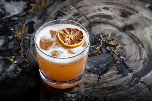 a drink with an orange slice on a wooden table at JW Marriott Savannah Plant Riverside District in Savannah
