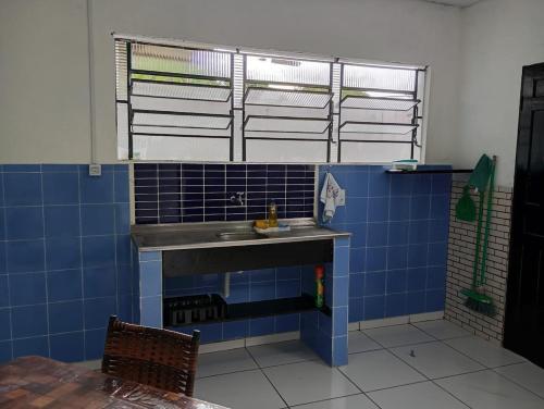 ein Badezimmer mit blau gefliesten Wänden und einem Waschbecken in der Unterkunft Casa perto da praia em Mosqueiro-PA in Belém