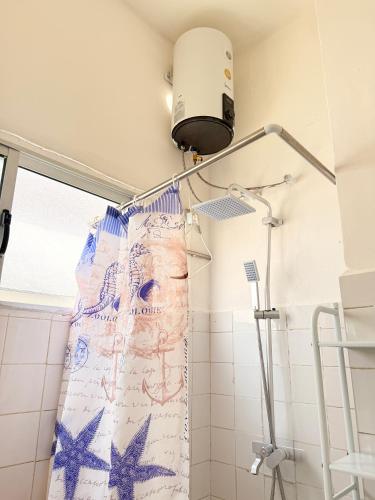 ein Bad mit einem Duschvorhang und einer Lampe in der Unterkunft Cozy & Secure 1BR Apartment in Central Luanda in Luanda
