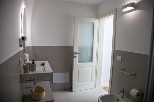 a bathroom with a toilet and a sink and a door at Dimora Di Nardo in Catania