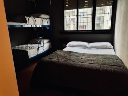 a small room with two bunk beds and two windows at Lacandona Hostel in Cordoba