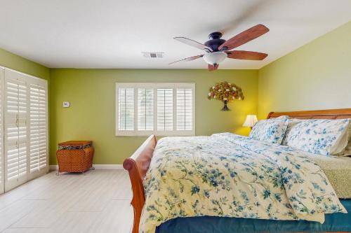 een slaapkamer met een bed en een plafondventilator bij La Quinta Vacation Pool Home in La Quinta
