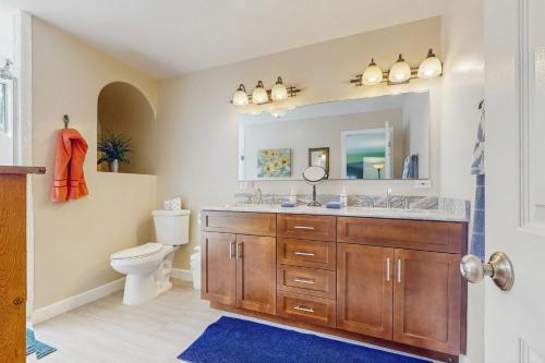een badkamer met een wastafel, een toilet en een spiegel bij La Quinta Vacation Pool Home in La Quinta