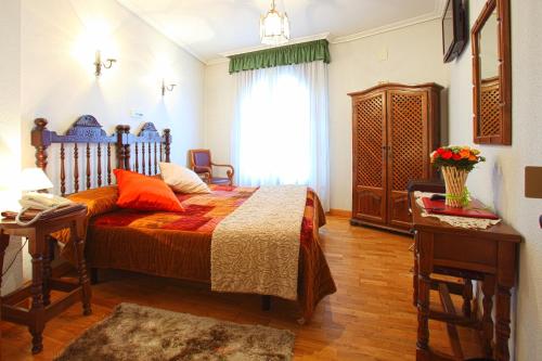 a bedroom with a bed with orange pillows and a window at Hotel Merindad de Olite in Olite