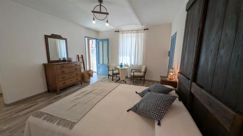 a bedroom with a large bed with a dresser and a mirror at B&B Freedoms Reins Farm in Casalborgone