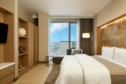 a hotel room with a large bed and a large window at The Westin Flushing LaGuardia Airport in Flushing