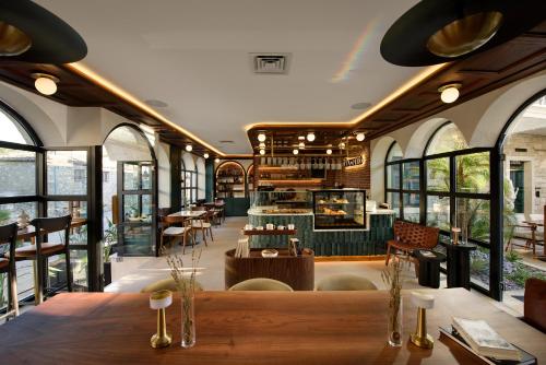 a restaurant with a table and chairs and windows at Tinspiro Alaçatı in Alacati