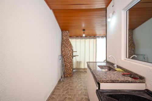 a bathroom with a sink and a mirror at Rental Palhoça - Acomodações Residenciais IV in Palhoça