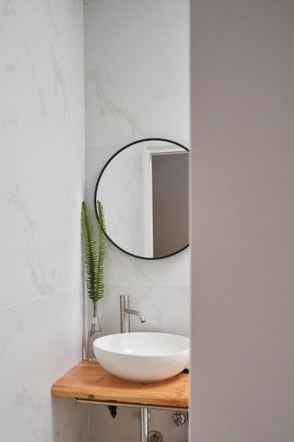 a bathroom with a white sink and a mirror at Sky House by Everkind in Bicas