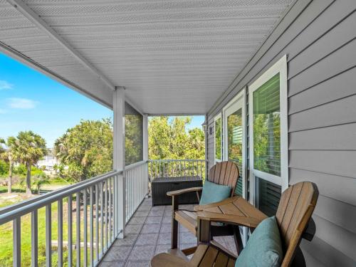 a porch with two chairs and a table at Riverfront Condo w Water Views-Heated Pool in Port Charlotte