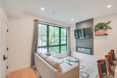 a living room with a couch and a window at Near Biotechs and MIT Cozy Condo with Fireplace in Cambridge