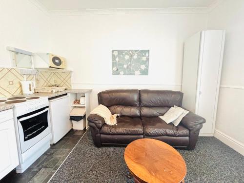 a living room with a brown leather couch and a table at Springfield Holiday Apartments HALodge Hotel in Skegness