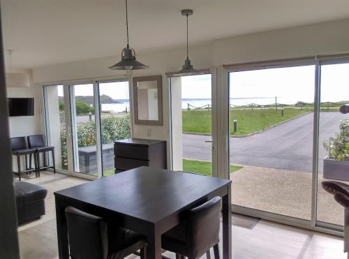 d'une salle à manger avec une table, des chaises et des portes coulissantes en verre. dans l'établissement Apartment Brittany facing and seaside, à Plomodiern