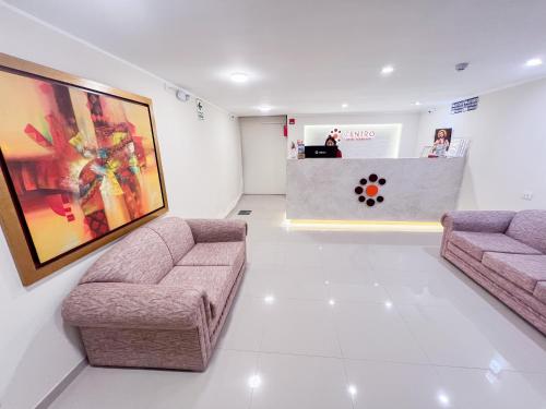 una sala de estar con 2 sofás y un mostrador en Hotel Centro Huancayo, en San Antonio