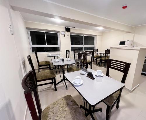 Hotel Centro Huancayo في San Antonio: غرفة طعام مع طاولات وكراسي ونوافذ