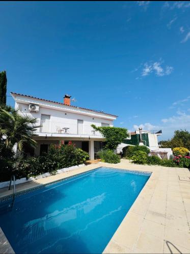 a swimming pool in front of a house at Exclusiva casa con vistas despejadas al mar y piscina privada in Lloret de Mar
