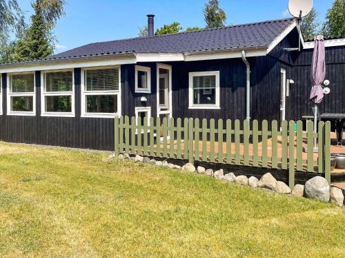 a blue house with a fence in front of it at 4 person holiday home in Hals in Hals
