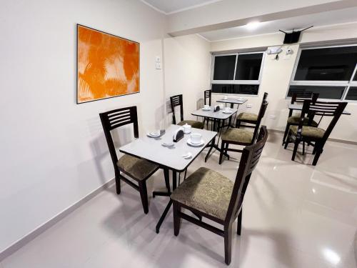 Un comedor con mesas y sillas y un cuadro. en Hotel Centro Huancayo, en San Antonio
