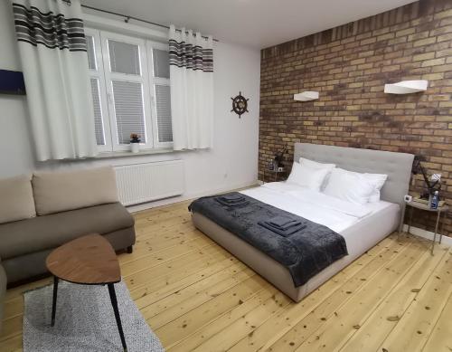 a bedroom with a large bed and a couch at Apartament Kapitański in Gdynia