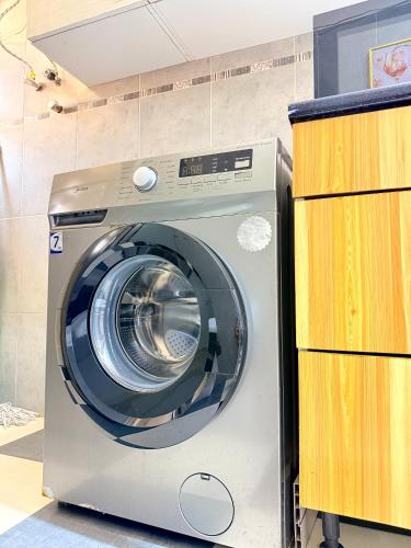 a washing machine sitting next to a wooden cabinet at Peaceful and Spacious Apartment at Luanda Bay in Luanda