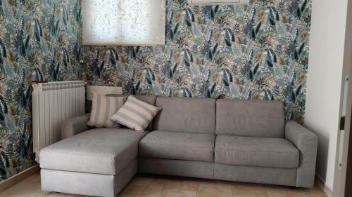a couch in a living room with a floral wallpaper at Gigli di mare in Santa Severa