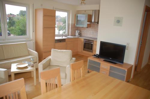 a living room with a couch and a tv and a table at Haus Rechteck in Grömitz