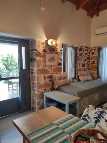 a living room with two beds and a table at To Pefko in Perdhika