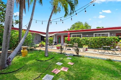 a garden with palm trees and a building at Sunny 1BR Hollywood Retreat – Pet Friendly in Hollywood